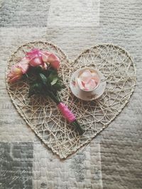 High angle view of pink roses on heart shape on table