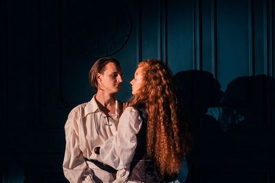 Young couple standing against wall