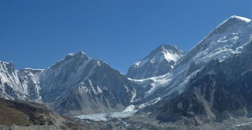 Scenic view of snowcapped mountains against clear blue sky