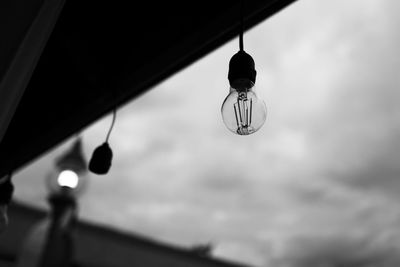 Low angle view of light bulbs hanging from ceiling