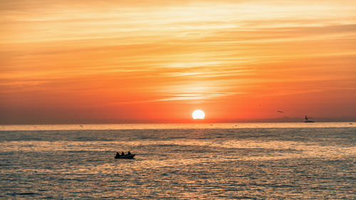 Scenic view of sea against orange sky