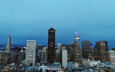 Illuminated buildings in city against sky