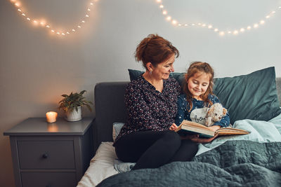 Mother reading book her daughter in bed before going to sleep. reading stories before sleep. bedtime