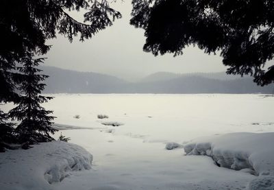 Scenic view of lake against sky during winter