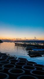 Pier over sea against clear sky during sunset