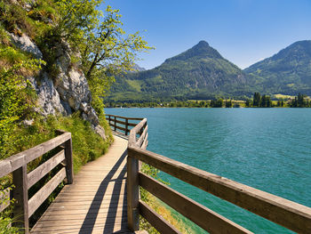 Scenic view of lake by mountains against sky