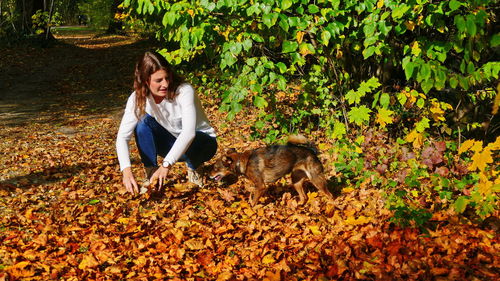 Young woman with autumn leaves on plants