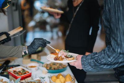 Midsection of people having food in restaurant