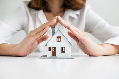 Midsection of woman holding umbrella on table in building
