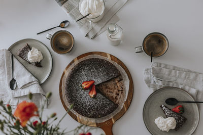 Freshly baked chocolate cake with strawberries on cream on table