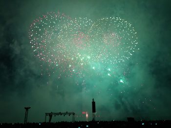 Low angle view of fireworks against sky at night