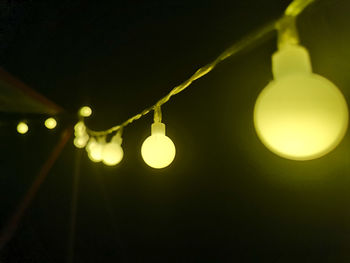 Low angle view of illuminated light bulb against the sky