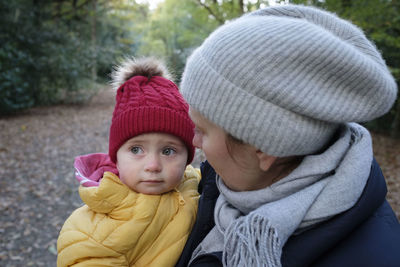 Close-up of woman holding crying son on road