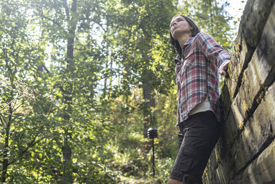 Low angle view of man standing in forest