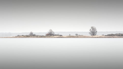 Scenic view of lake against clear sky during winter