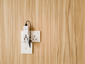 Close-up of electrical socket on wooden wall