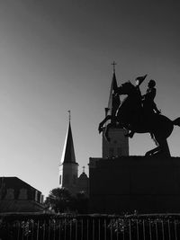 Statue in city against sky