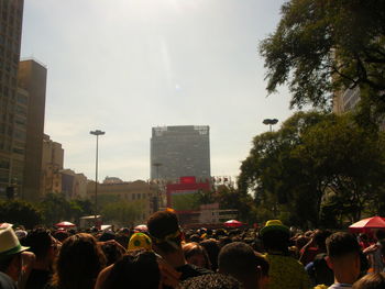 Crowd on city street against sky