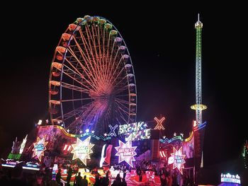 Low angle view of illuminated ferris wheel at night