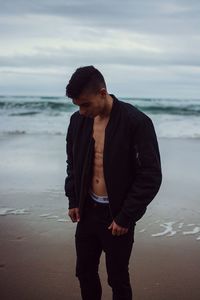 Man standing on beach against sky