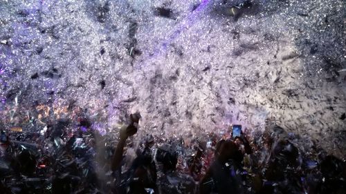 Confetti over people enjoying music concert at night