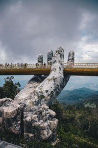 Bridge over rocks against sky