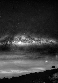 Silhouette mountain against sky at night