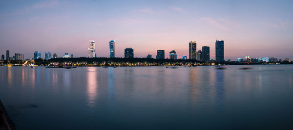 Illuminated buildings in city against sky