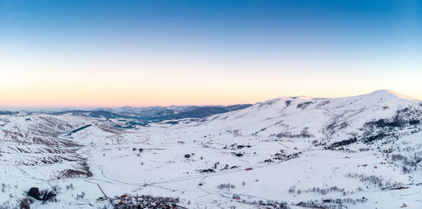 Scenic view of snowcapped mountains against clear sky