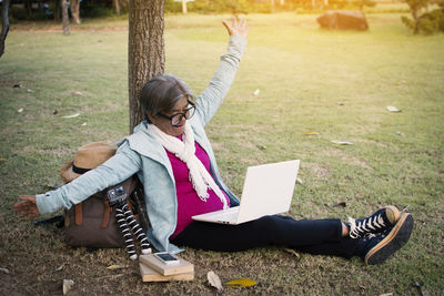 Senior woman using laptop while sitting at park