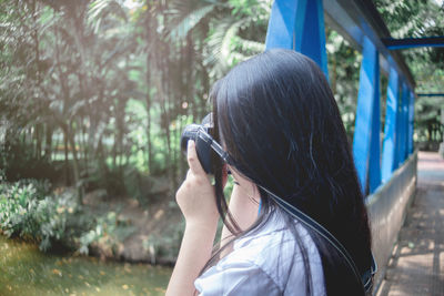 Portrait of woman photographing outdoors