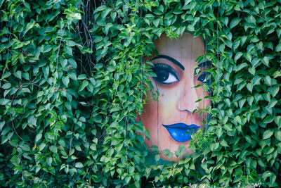 Portrait of young woman with plants