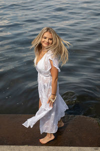 Portrait of a smiling young woman standing in water
