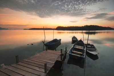 Boats on calm lake at sunset