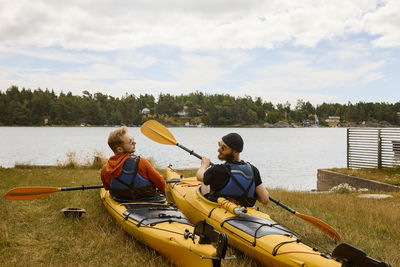 Men sitting in kayaks at coast