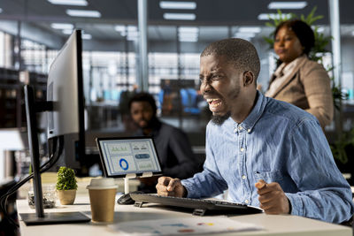 Portrait of man using mobile phone at table