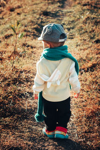 Rear view of boy standing on field