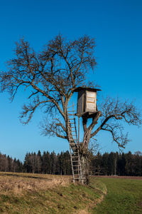 Built structure on field against clear blue sky