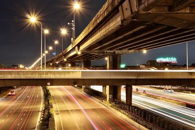 Light trails on bridge in city at night