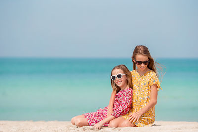 Woman wearing sunglasses on beach against sky