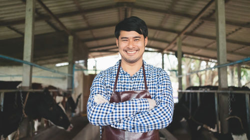 Portrait of young man standing in factory