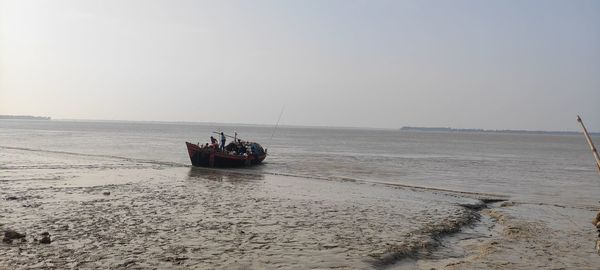People in boat on sea against sky