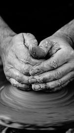 Cropped hands of potter making craft product