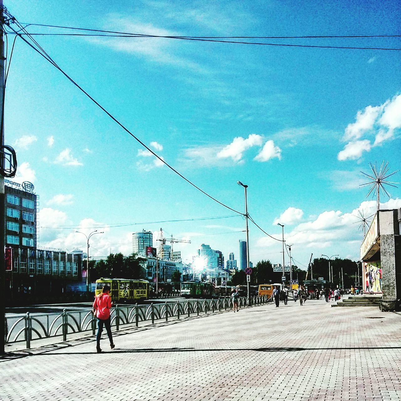 power line, cable, sky, electricity pylon, building exterior, transportation, built structure, architecture, street, power supply, electricity, city, power cable, cloud - sky, men, road, cloud, connection, street light