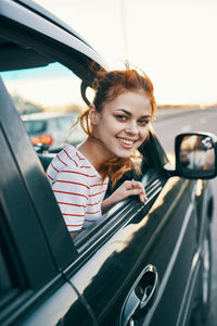 Portrait of smiling young woman in car