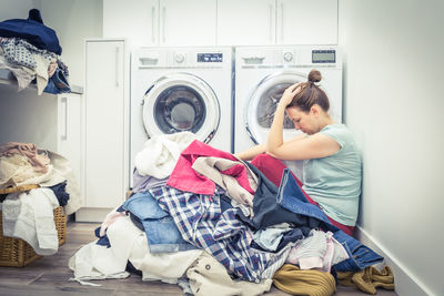 Side view of frustrated woman at laundromat