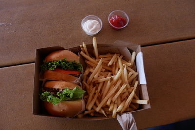 High angle view of burgers with french fries on table