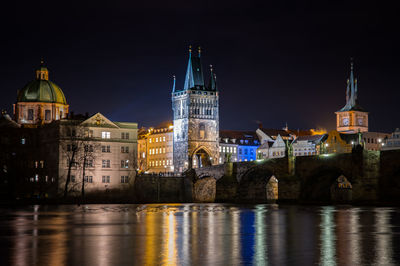 Illuminated buildings against sky at night