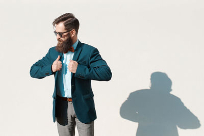 Portrait of businessman standing against white background