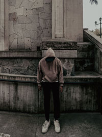 Rear view of man standing against building